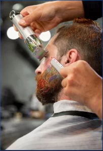 Tatuador y cliente revisando juntos el estarcido colocado sobre el antebrazo antes de empezar, con la máquina y el material preparados sobre la mesa del estudio